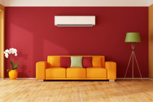Does Adding Insulation to Your Attic Make a Big Difference? Red and orange living room with colorful sofa and air conditioner.