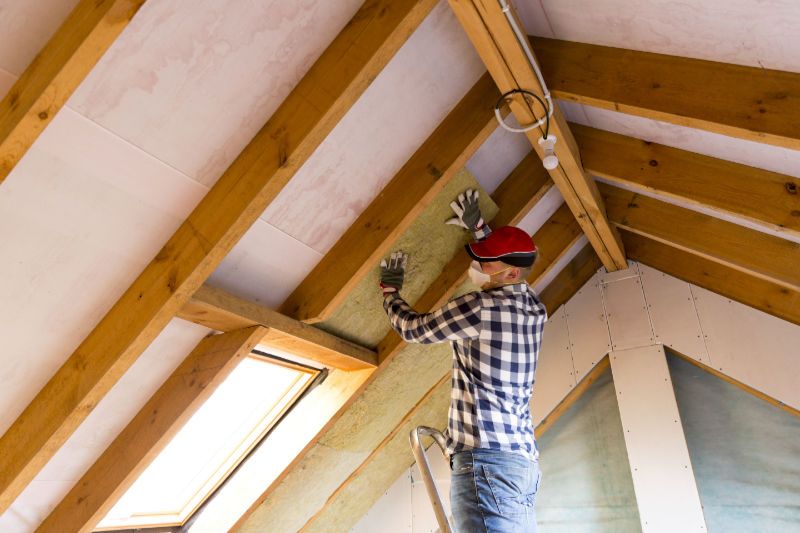 Image of someone installing ceiling insulation in an attic. Do I Need Ceiling Insulation?